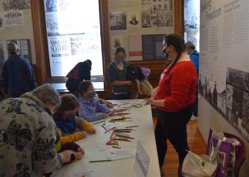 Abigail interacting with visitors at the booth.